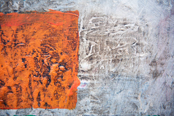 Close-up of abstract painted wall with bold orange color block on textured surface, modern art background with strong contrast and copy space.