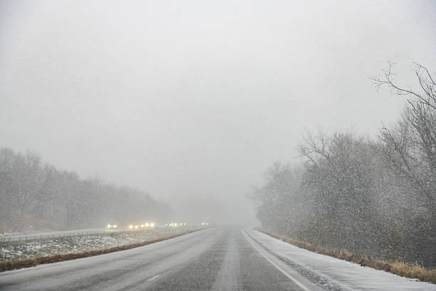 This is a photograph of the view through a car windshield while on a road trip through rural Pennsylvania on a winter day during a snowstorm with low visibility.
