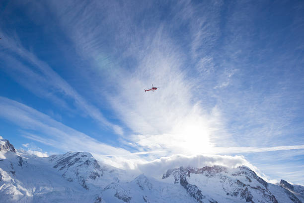 Helicopters fly through the swiss alps throughout winter taking vacationers on joy flights as well as providing safety against avalanches and rescue