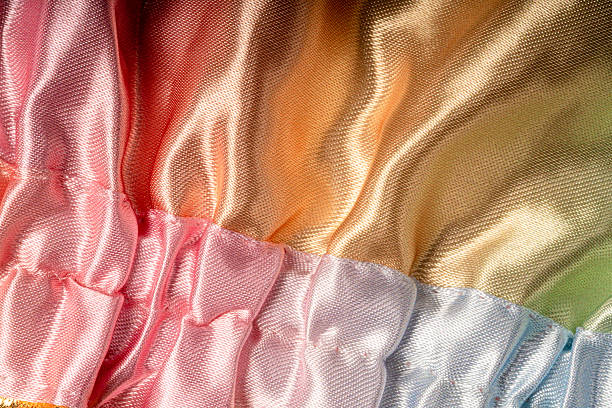Shiny fabric texture with soft folds, abstract luxury textile background with pastel colors, elegant material surface for fashion and design concepts