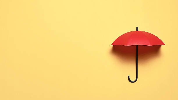Minimalist Red Umbrella on Yellow Background Representing Protection Insurance and Unique Leadership