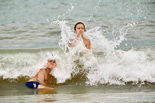 Playful boys having fun during summer day in sea. Copy space. Photographed in medium format.