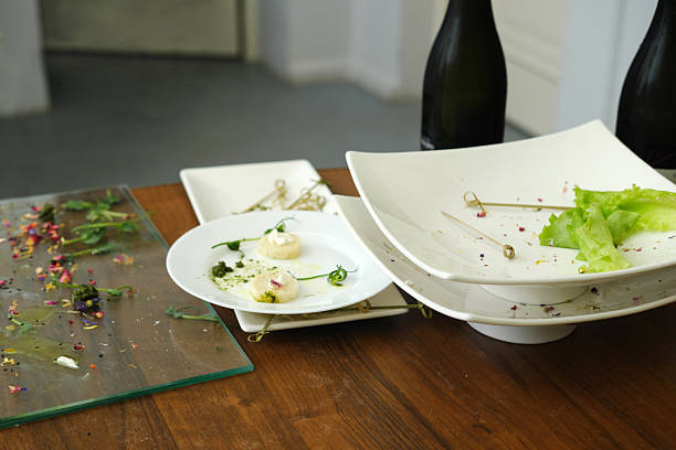 Dining table features empty plates with remnants of gourmet dishes, highlighting culinary artistry and fine dining experience in a contemporary atmosphere