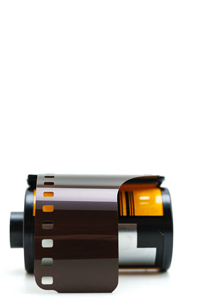 A film roll sits on a plain surface. It is prepared for capturing moments in photography. The roll is unwrapped and shows the exposed film inside.