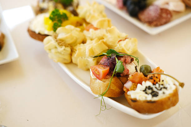 Assorted gourmet appetizers displayed on a white platter, showcasing a variety of textures and colors, perfect for elegant gatherings and culinary events