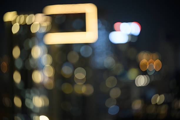 Vibrant lights of a blurred city skyline at night, the scene is illuminated by a mesmerizing display of bokeh effects, creating a captivating and atmospheric ambiance.