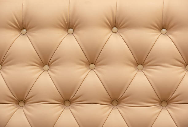 Beige tufted leather creating a classic pattern for upholstery, furniture, and headboards
