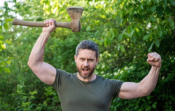 aggressive man with axe wearing shirt. aggressive man with axe outdoor. photo of aggressive man with axe. aggressive man with axe.