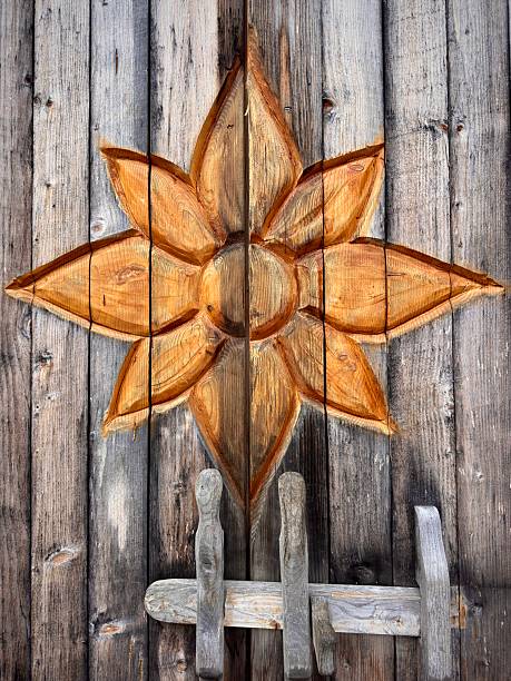 Background image of a wooden surface with a rounded shape sun carved on it.
