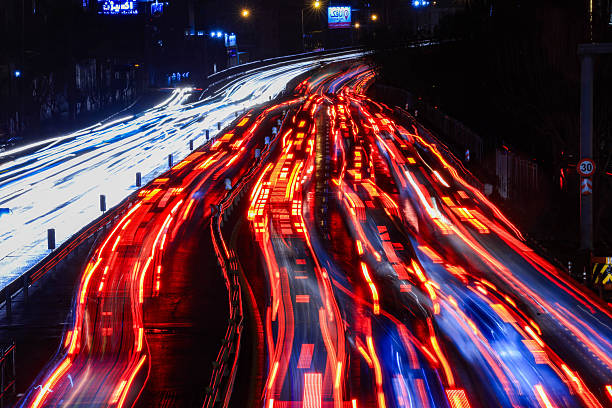 Defocused city traffic lights at night forming colorful bokeh, ideal for abstract urban backgrounds and modern design concepts.