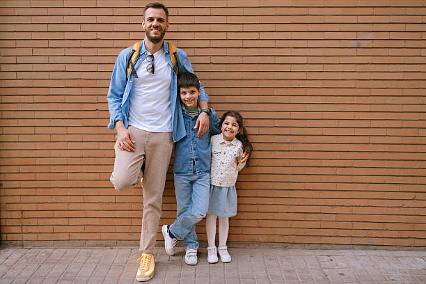 Family Portrait Standing Against Brick Wall