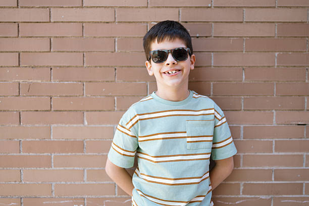 Portrait of Young Boy Against Brick Wall