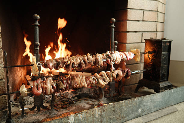 Spit-roasted meat turning over glowing embers in a rustic brick fireplace, slow-cooked, savory country-style dinner ambiance