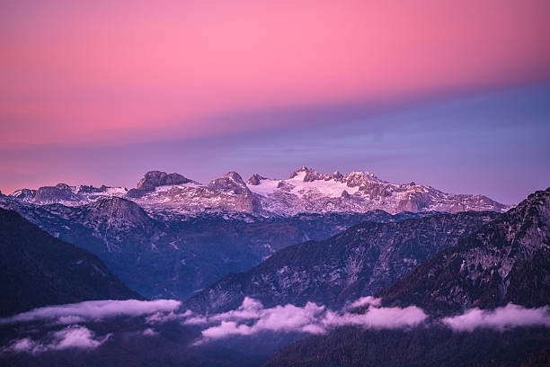 light pink colored sky over Dachstein mountain range with some snow and glacier on early morning in autumn