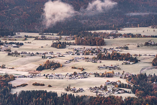 view from mountain above village surrounded by forest on cold frosty morning in autumn