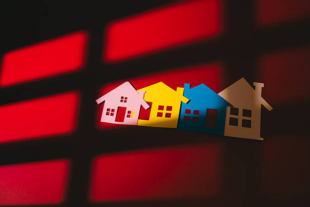 istock Real Estate concept. Colorful paper houses on red background with shadow grid pattern create warm and cozy feeling of home and community in this artistic composition 2260261481
