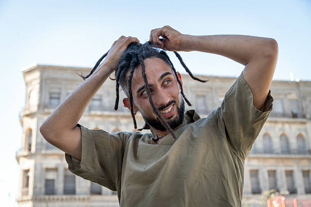 Caribbean man posing for the camera with a smile. Horizontal image of black man with long hair.