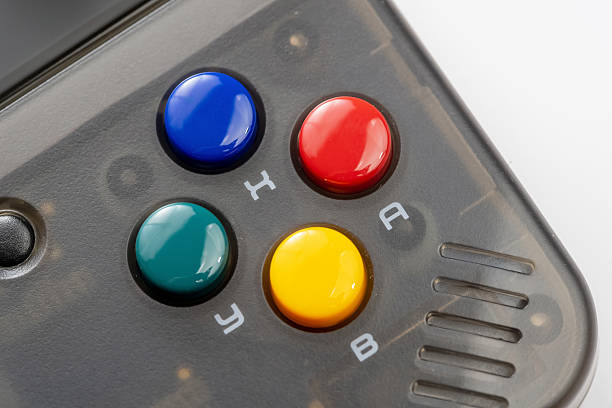 Retro handheld game console colorful A B X Y action buttons macro, extreme closeup Translucent black plastic controller, red green blue yellow keys, gaming device detail, nobody, retro gaming symbol
