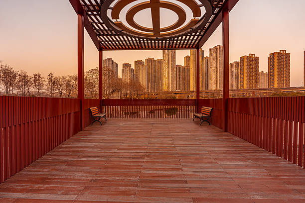 Empty wooden observation terrace and modern city skyscrapers at dusk