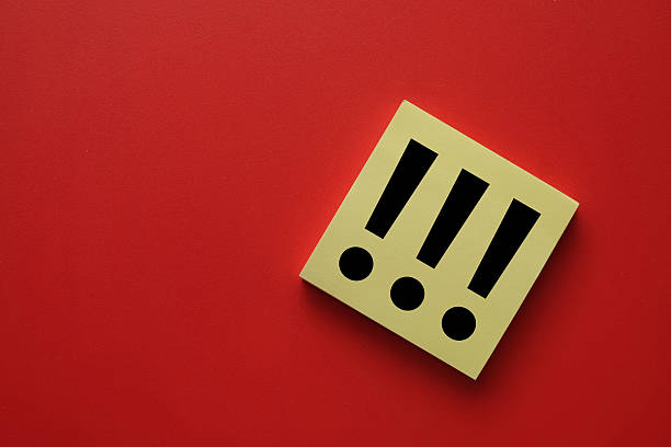 Top view of yellow sticky note with three exclamation marks symbol on red background with copy space. Danger alert, warning, emergency stop, and urgent attention concept.