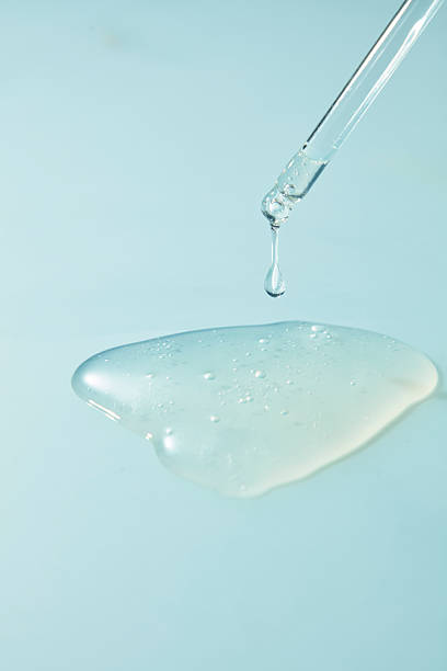 istock Glossy serum puddle with dropper on blue background. Abstract cosmetic texture representing hydration, freshness, and modern skincare product design 2260314084