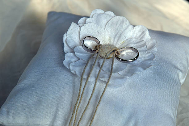 wedding rings on a decorated white cushion