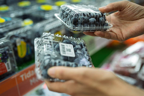 Customer Buying Fresh Blueberries in Plastic Containers at Supermarket Produce Section