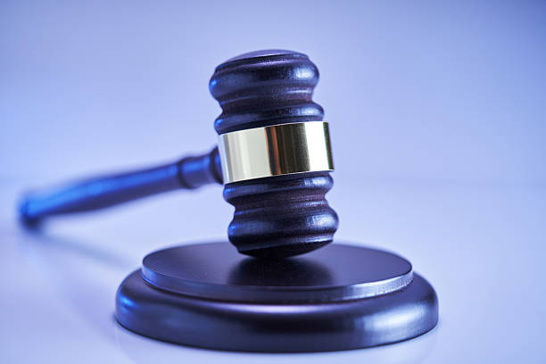directly above of hand holding gavel hammer on red background