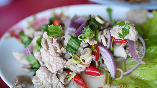 Fresh and vibrant dish featuring sliced pork, herbs, and vegetables, showcasing colorful presentation and inviting flavors