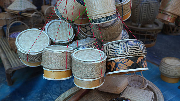 Handcrafted baskets made from natural materials, showcasing intricate designs and textures, hang in vibrant market setting