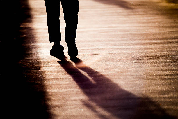 light and shadow person walking on the street