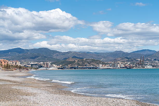 Malaga coastline with port and mountains under clouds, Spain