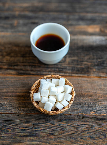 Minimal coffee cup with sugar cubes on rustic background. Using sugar in coffee.