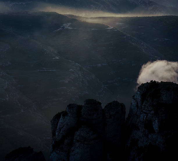 Mystical mountain landscape at sunset with dramatic cliffs, clouds, and soft fog. Aerial-style view of Montserrat creating a peaceful and cinematic atmosphere.
