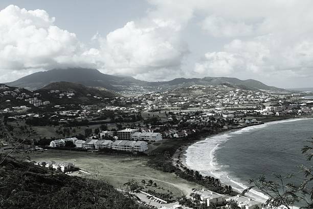 Views of a bay in St Kitts, featuring water, buildings, mountains, sky, clouds and besutifuk scenery