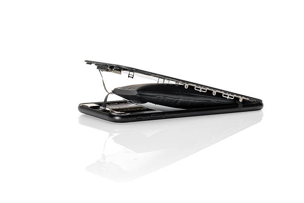 Swollen lithium polymer battery in smart phone on white reflective background.