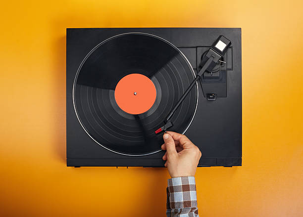 Hand is moving the tonearm of turntable LP record player to playing position