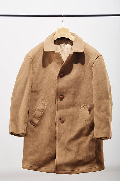 A vintage beige military style jacket featuring decorative cords and buttons isolated on a white background