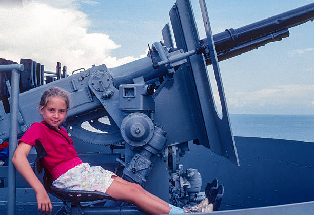 Battleship Alabama - Girl seated at a deck gun - 1991. Scanned from Kodachrome 64 slide.