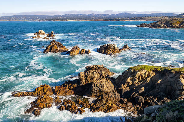 Pacific Ocean waves strike rugged coastal cliffs at Point Lobos State Natural Reserve in California