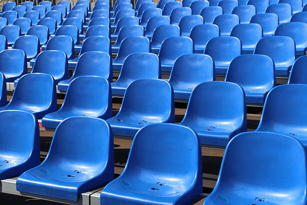 Rows of empty blue plastic chairs for audience and supporters
