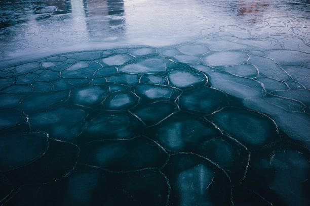 Ice covers sections of Copenhagen Harbor in Denmark, creating distinctive circular patterns and formations across the frozen waterway. The unusual winter cold snap on February 3, 2026 has transformed the normally navigable harbor into a frozen landscape with geometric ice patterns. The scene shows the extensive ice coverage with reflections of buildings visible in the partially frozen surface.