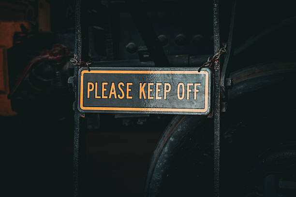 A weathered metal sign with yellow lettering reading 
