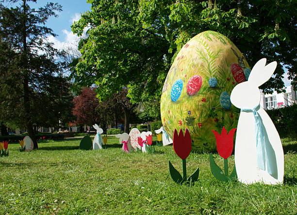 Little Easter bunny toys and Easter eggs on a green grass. Fairy tale