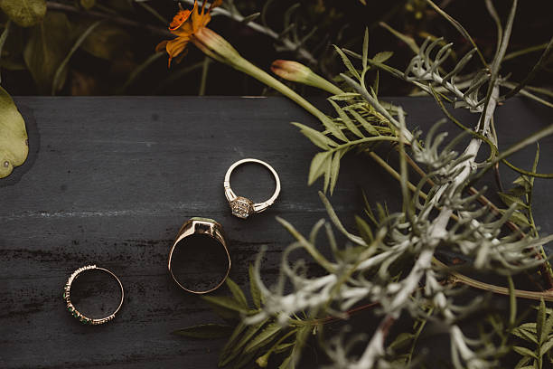 Bride and groom wedding rings with flowers and copy space