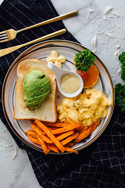 Delicious Healthy Breakfast with Avocado, Scrambled Eggs and Sweet Potatoes