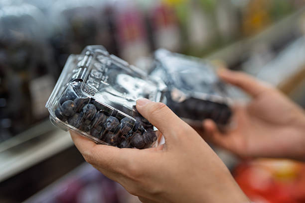 Customer Buying Fresh Blueberries in Plastic Containers at Supermarket Produce Section