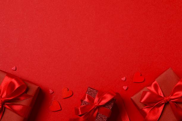 istock Festive postcard with beautiful gift boxes with red hearts on color background, top view, space for text 2260487750