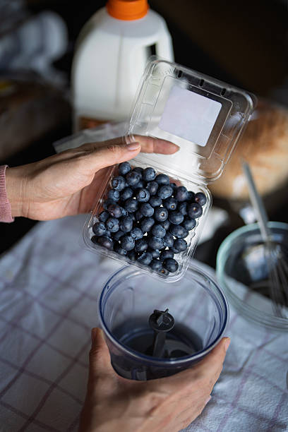 Hands Holding Fresh Blueberries Ready to Pour into Blender