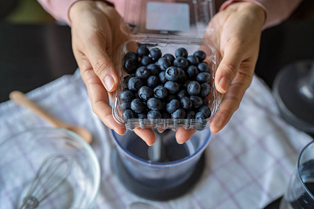 Hands Holding Fresh Blueberries Ready to Pour into Blender